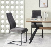 Schwingstuhl in dunkelgrauem Stoffbezug mit schwarzem Metallgestell neben Holzesstisch mit schwarzen X-Beinen, seitliche Perspektive im Esszimmer