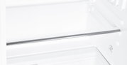 Innenraum eines Kühlschranks mit Glasablage und Metallleiste, Ansicht schräg von vorne in den leeren Kühlraum