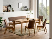 Modernes Esszimmer-Set mit rechteckigem Holzesstisch, gepolsterter Sitzbank und vier braunen Stühlen auf Teppich, fotografiert in leichter Schrägansicht von vorn.