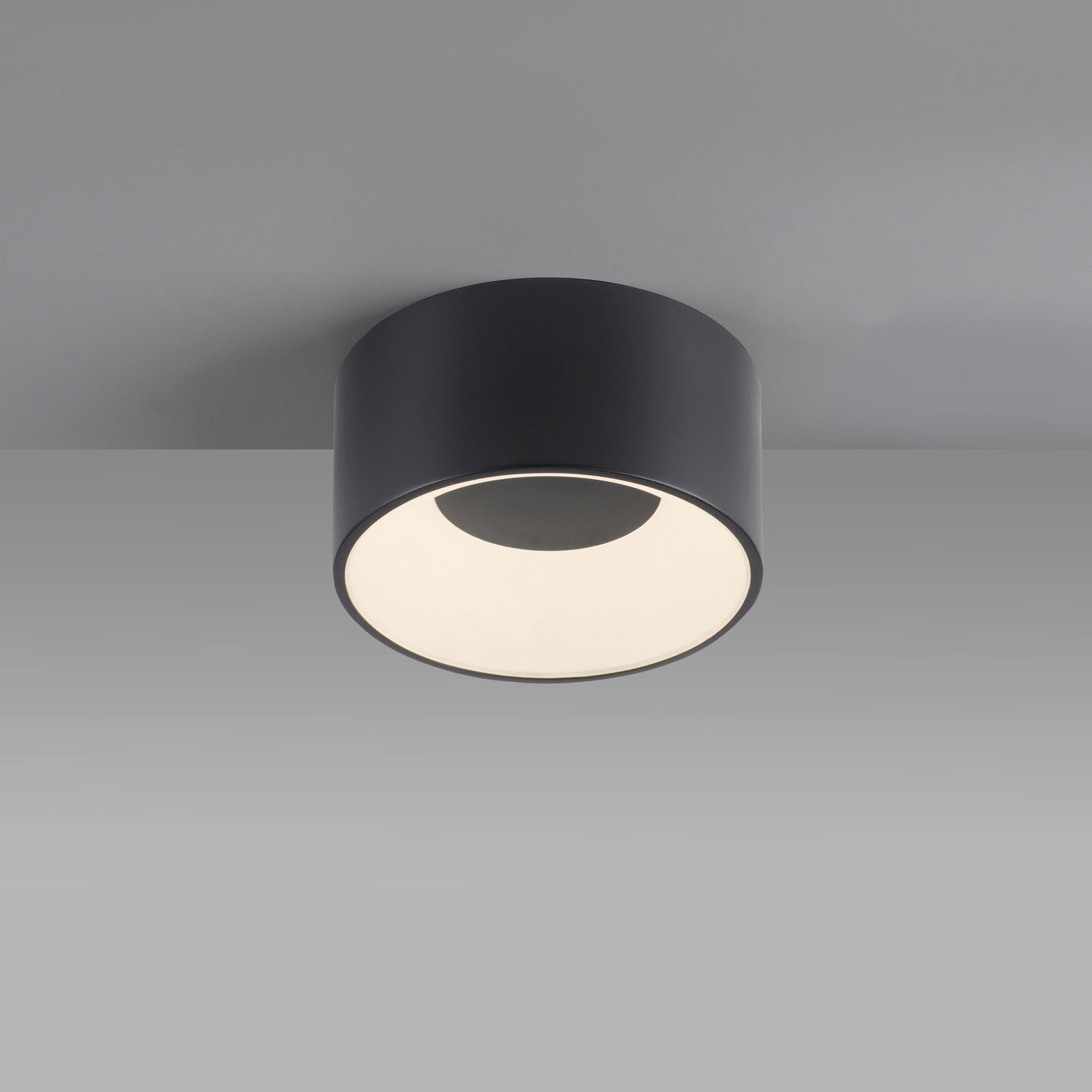 Moderne Deckenleuchte TANIKA in zylindrischer Form, schwarze Oberfläche, von unten betrachtet.