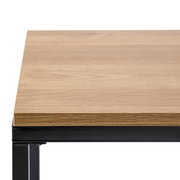 Nahaufnahme eines Beistelltisches mit Holzplatte und schwarzem Metallrahmen, von oben betrachtet.