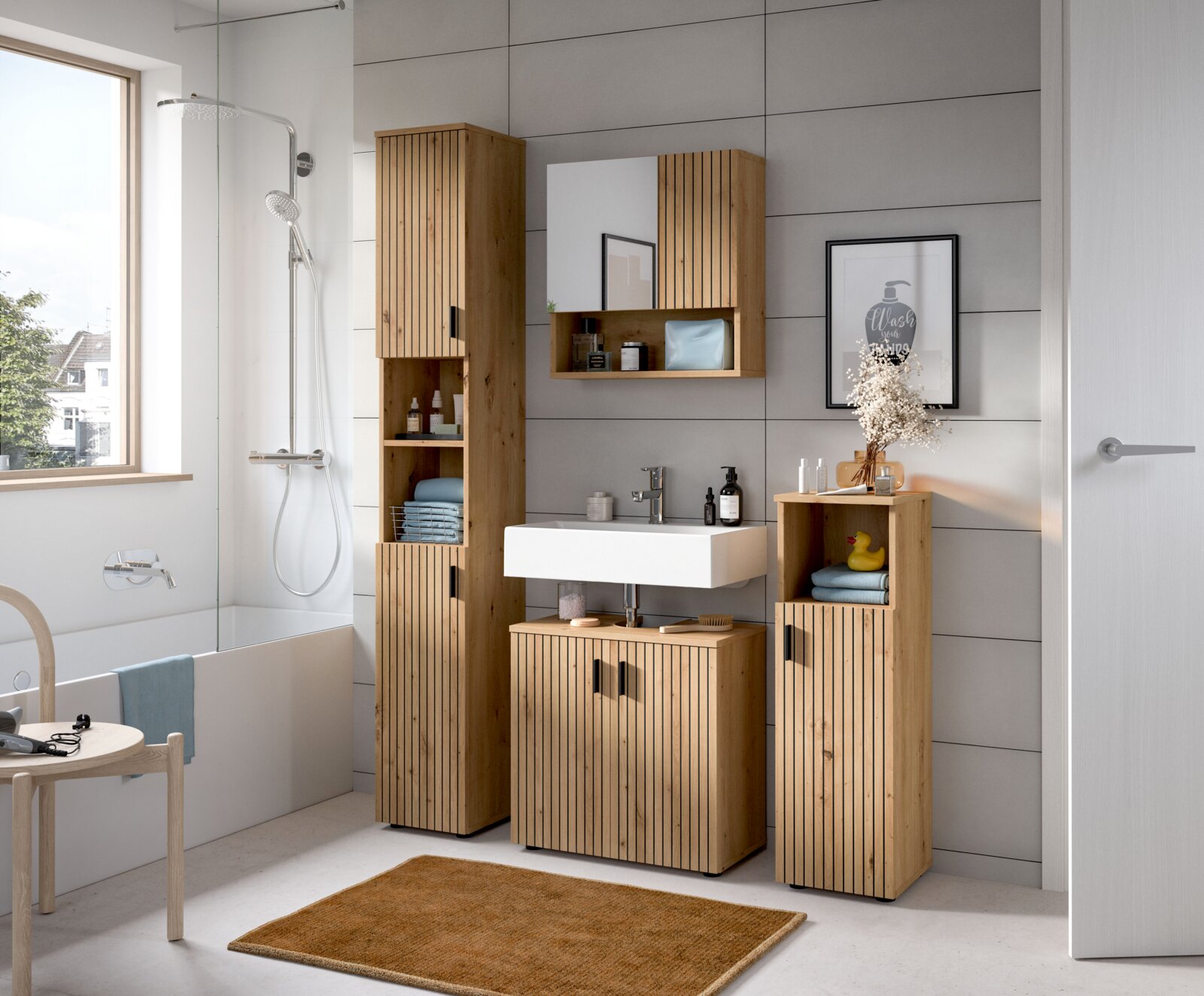 Modernes Badezimmermöbel-Set in Holzoptik mit vertikaler Lamellenfront, Hochschrank, Waschtischunterschrank und Spiegelschrank über weißem Waschbecken, fotografiert in frontaler Perspektive mit leichter Seitenansicht.