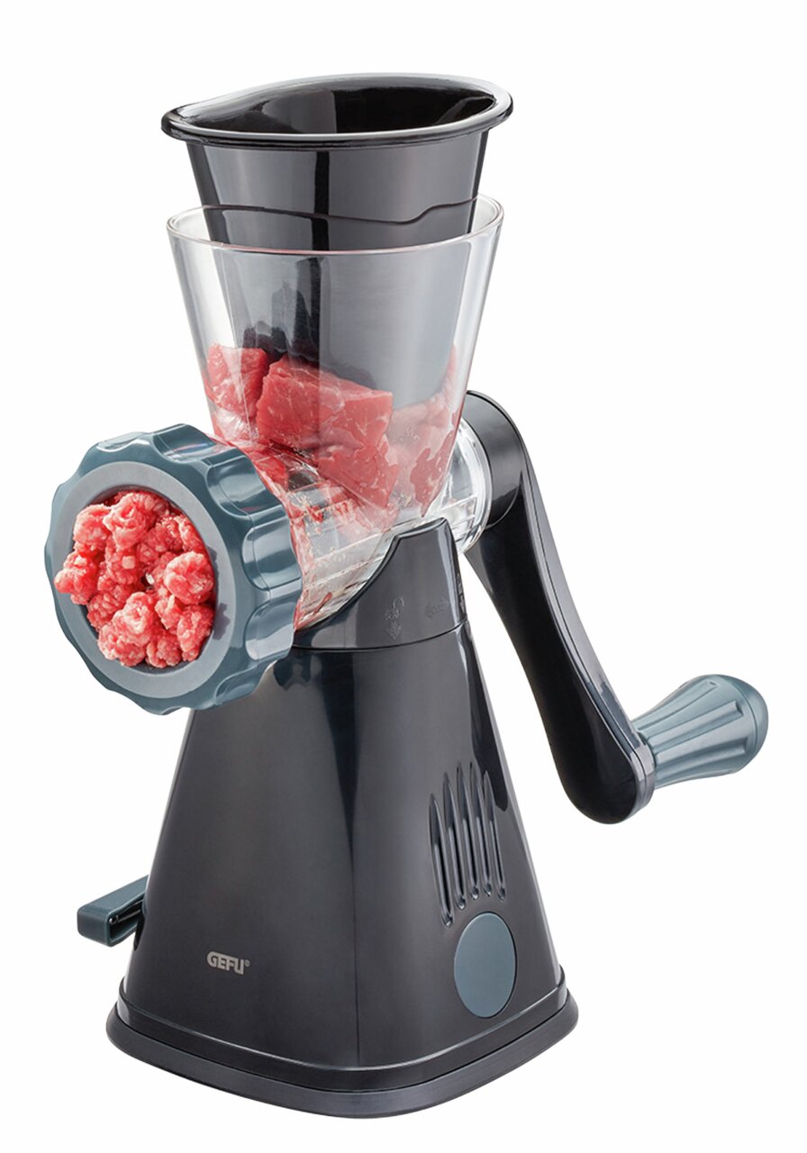 Fleischwolf METO in seitlicher Perspektive mit Fleischstücken im Trichter und frisch gemahlenem Hackfleisch vorne.