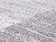 Nahaufnahme eines Frisé-Teppichs in Grautönen mit weicher, strukturierter Oberfläche.