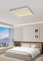 Moderne LED-Deckenleuchte in quadratischer Form, von unten betrachtet, in einem stilvollen Schlafzimmer mit großen Fenstern und minimalistischer Einrichtung.