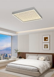 Moderne LED-plafondlamp in vierkante vorm, gezien van onderaf, in een stijlvolle slaapkamer met grote ramen en een minimalistische inrichting.