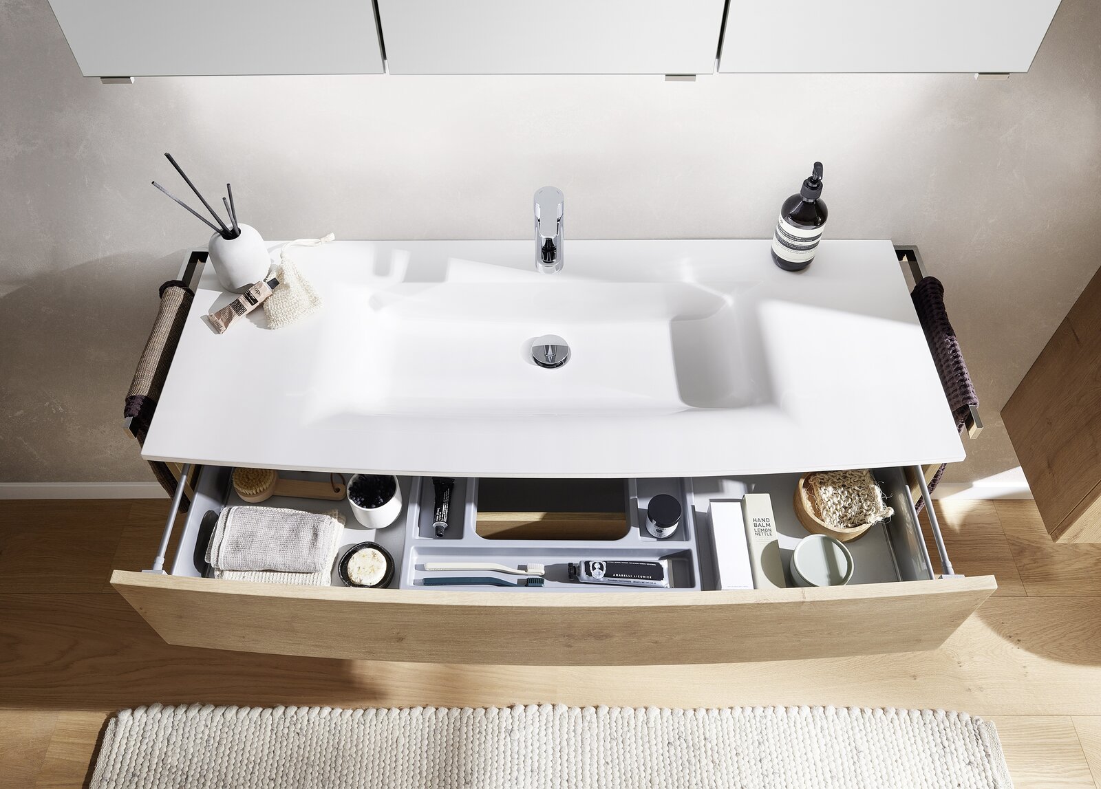 Moderne Badkombination mit Waschbecken und geöffneter Schublade, von oben betrachtet.