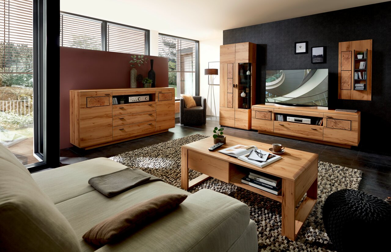 Wohnzimmer mit moderner Holzmöbelkombination, bestehend aus Sideboard, Wandkombination und Couchtisch, aus der Perspektive eines Sitzplatzes auf dem Sofa.
