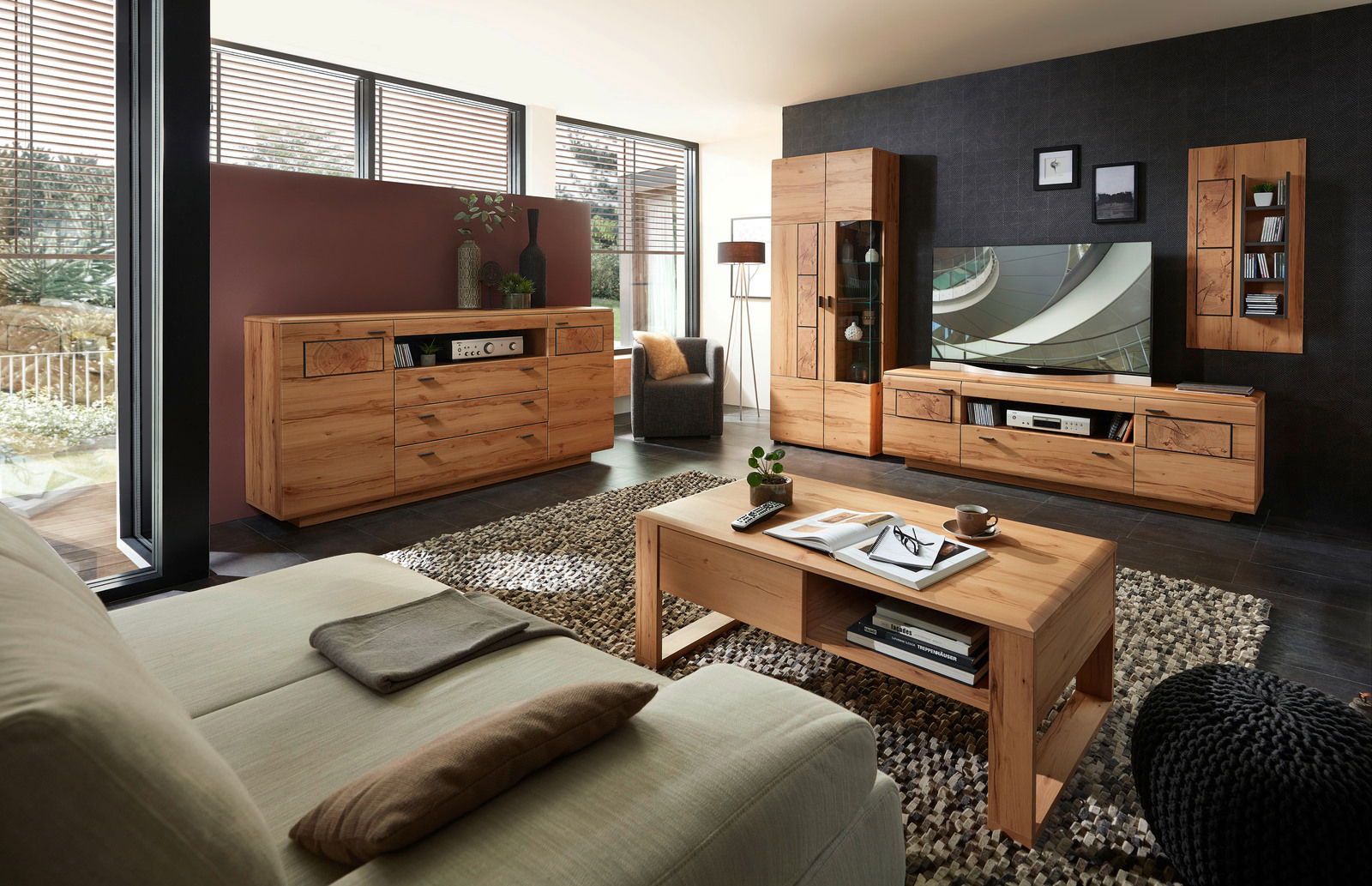 Wohnzimmer mit moderner Holzmöbelkombination, bestehend aus Sideboard, Wandkombination und Couchtisch, aus der Perspektive eines Sitzplatzes auf dem Sofa.