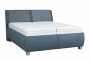 Polsterbett in blauer Farbe mit weißer Matratze, seitliche Perspektive