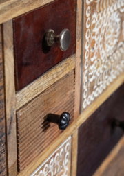 Close-up van een dressoir met verschillende houten lades en decoratieve knoppen, zijaanzicht