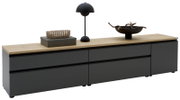 Modernes, niedriges Sideboard/TV-Board mit mattschwarzen Fronten und heller Holzplatte, dekoriert mit Lampe, Korb und Schale; perspektivische Ansicht leicht von vorne rechts