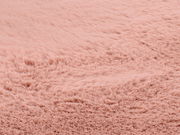 Nahaufnahme eines rosafarbenen Fellteppichs mit weicher, flauschiger Textur.