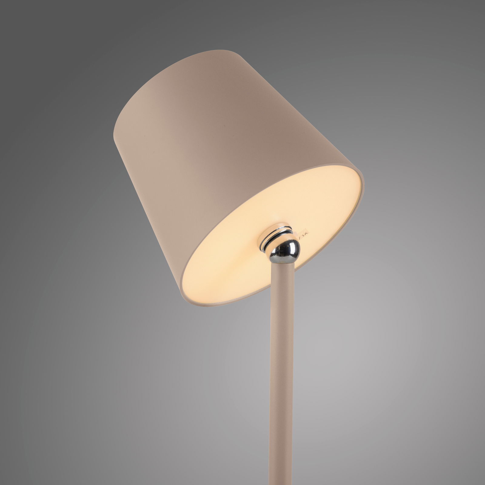 Nahaufnahme einer Akku-Tischleuchte BOTERIA mit einem schlichten, modernen Design in Beige, seitliche Perspektive.