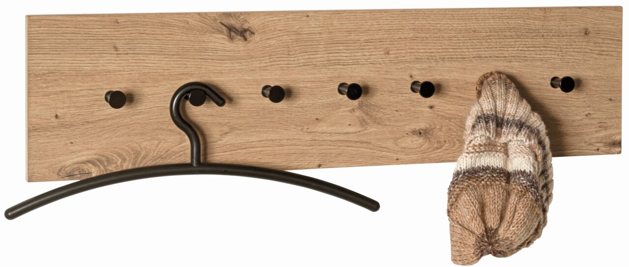 Houten wandkapstok met zes zwarte haken, afgebeeld van voren. Aan de haken hangen een zwarte kleerhanger en een gebreide muts.