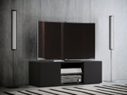 Modernes Wohnzimmer-Setup mit großem Flachbildfernseher auf schwarzem Lowboard, flankiert von zwei schlanken Stehleuchten vor Betonwand; frontale Perspektive.