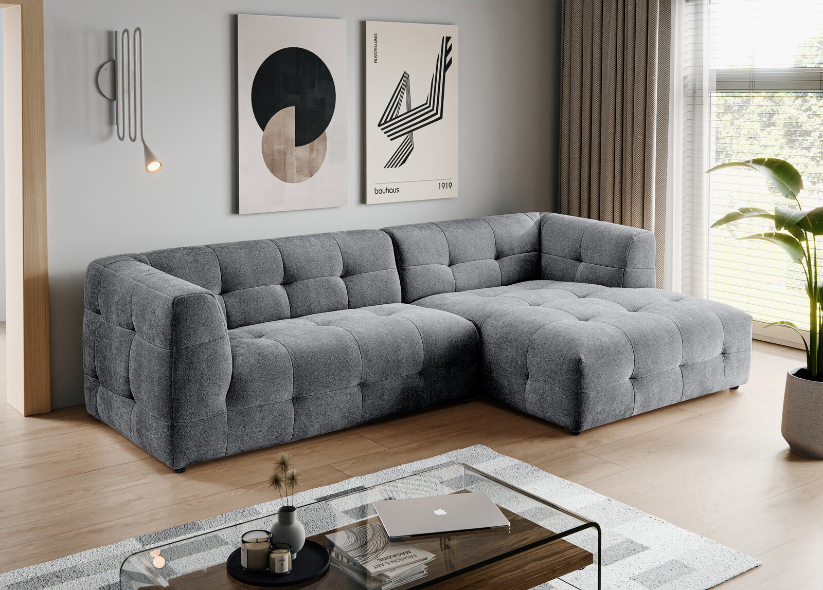 MID.YOU Ecksofa TENSO Modernes graues, gepolstertes Ecksofa mit rechter Ottomane und quadratischer Steppung im Wohnzimmer, fotografiert in schräger Frontansicht von links.
