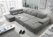 Graues Ecksofa in U-Form mit Bettfunktion, abgebildet aus einer erhöhten Perspektive in einem modernen Wohnzimmer.
