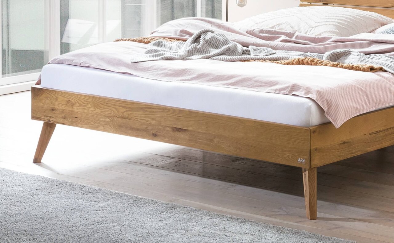 Holzbettgestell mit schrägen Beinen, seitliche Perspektive