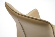 Close-up van een beige leren fauteuil, gezien van achteren