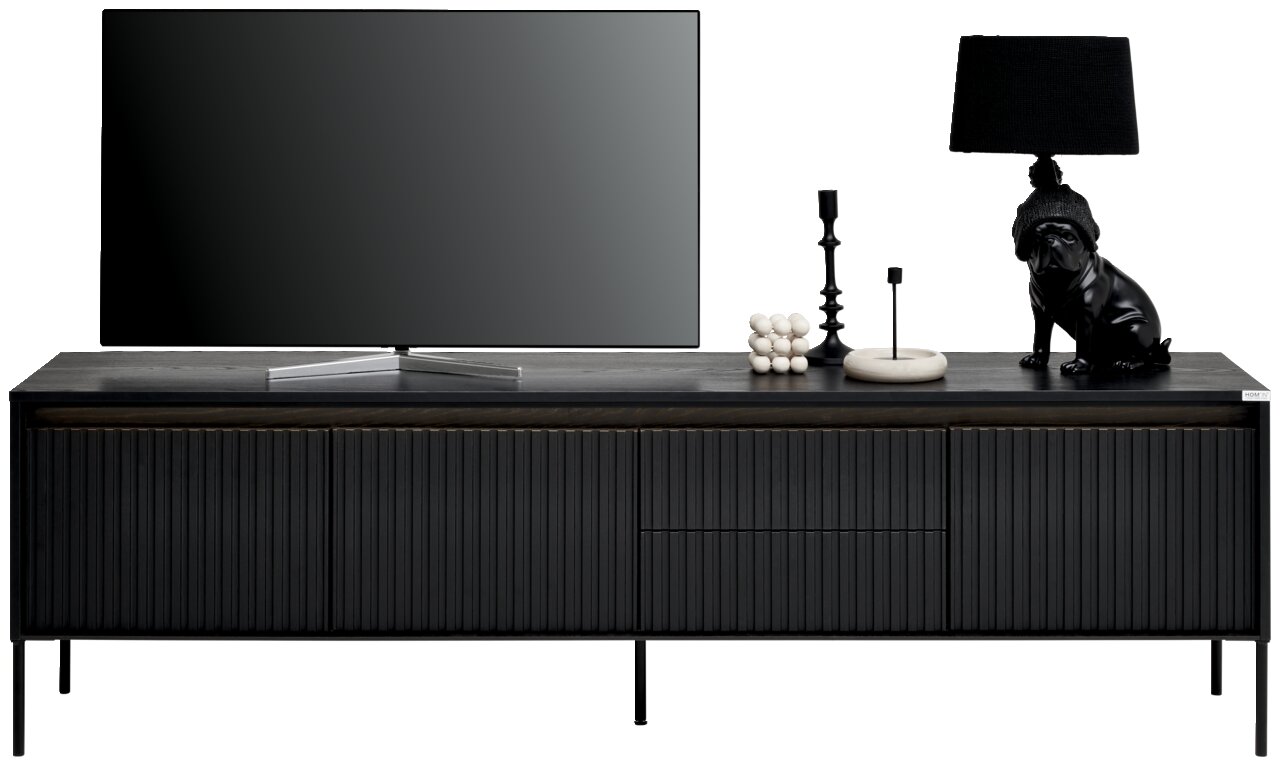Frontale Ansicht eines modernen, schwarzen TV-Lowboards mit gerillten Türen, dekoriert mit einem Fernseher, einer Lampe und Dekorationsobjekten.