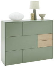 Grünes Highboard mit modernem Design, zwei Holzschubladen und dekorativen Objekten auf der Oberseite, aus frontaler Perspektive.