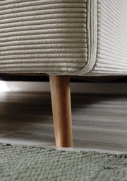 Nahaufnahme eines Polsterbettgestells mit Holzbein, seitliche Perspektive