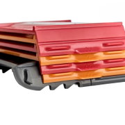 Stapel farbiger Kunststoffboxen/Organizer in Rot und Orange auf grauer Basis, Nahaufnahme aus schräger Seitenansicht.