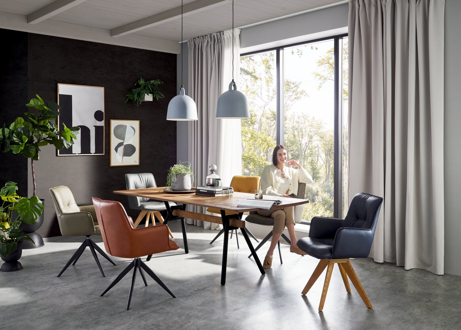 Valnatura Esstisch SALZBURG Modernes Esszimmer mit rechteckigem Holztisch und mehreren gepolsterten Drehstühlen in verschiedenen Farben, aufgenommen in frontaler, leicht seitlicher Perspektive auf Tisch und Stühle.