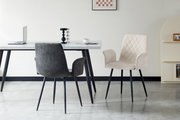 Zwei Armlehnstühle in einem modernen Esszimmer, einer in dunklem Grau und der andere in hellem Beige, mit einem Tisch im Hintergrund. Perspektive von vorne.