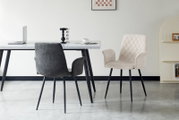 Twee stoelen met armleuningen in een moderne eetkamer, de ene in donkergrijs en de andere in lichtbeige, met een tafel op de achtergrond. Aanzicht van voren.