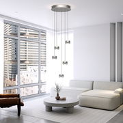 Moderne LED-Pendelleuchte mit fünf hängenden Leuchtkörpern in einem stilvollen Wohnzimmer mit großen Fenstern, seitliche Perspektive.