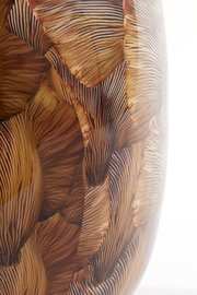 Close-up in zijaanzicht van een glanzende decoratieve vaas met een gelaagd bladmotief in warme bruintinten.