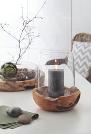 Windlicht mit Teakholz-Basis und Glasaufsatz, frontal fotografiert, mit brennender Kerze im Inneren.