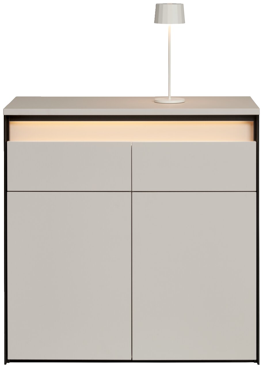Moderne Kommode in hellem Grau mit integrierter Beleuchtung und einer Tischlampe auf der Oberseite, Frontalansicht.