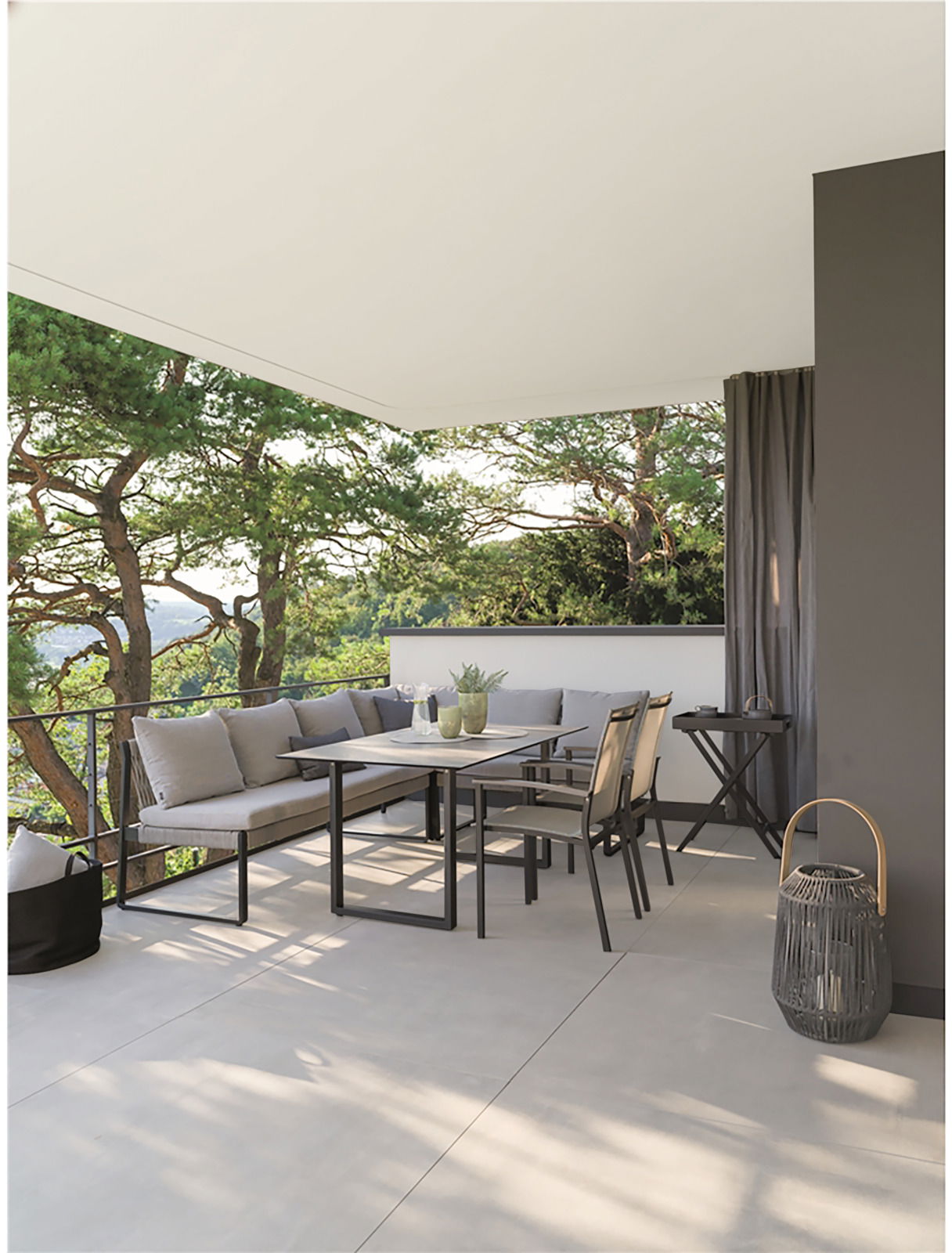 Stern 2-Sitzer Loungelement TAMMO Moderne Outdoor-Lounge mit Ecksofa und Esstisch auf einer Terrasse mit Blick auf Bäume, seitliche Perspektive