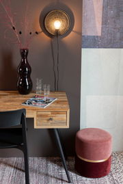 Runder, zweifarbiger Hocker in Rosa und Rot mit goldener Zierleiste, seitlich neben einem Holztisch mit schwarzem Stuhl platziert.