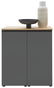 Frontale Ansicht einer modernen Kommode in Dunkelgrau mit hellem Holzdeckel, dekoriert mit einer schwarzen Schale und einer gemusterten Vase.