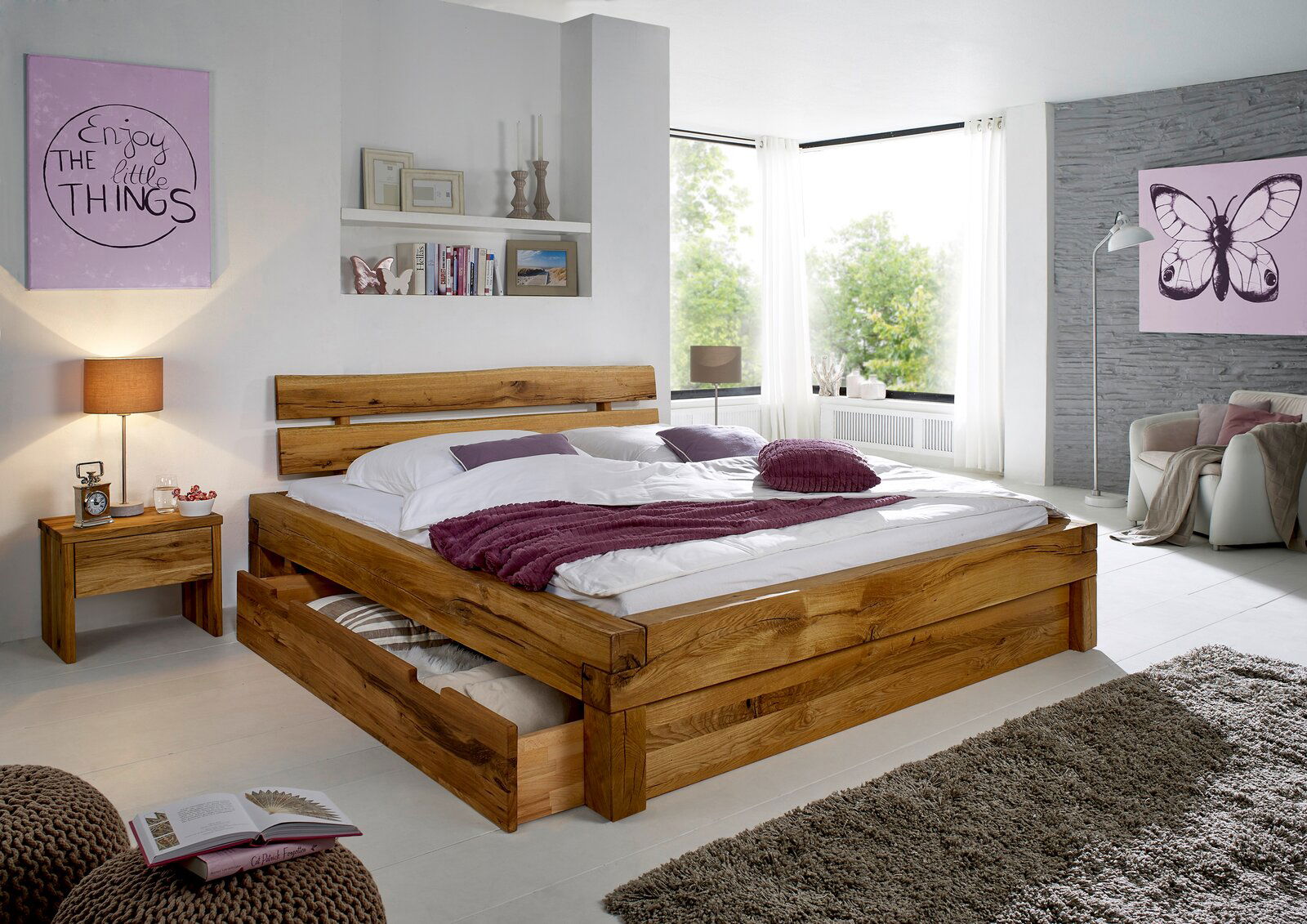 Linea Natura Schubkasten HORST Holzbett mit Schublade, Nachtkommode und dekorativen Kissen in einem modernen Schlafzimmer, seitliche Perspektive