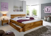 Holzbett mit Schublade, Nachtkommode und dekorativen Kissen in einem modernen Schlafzimmer, seitliche Perspektive