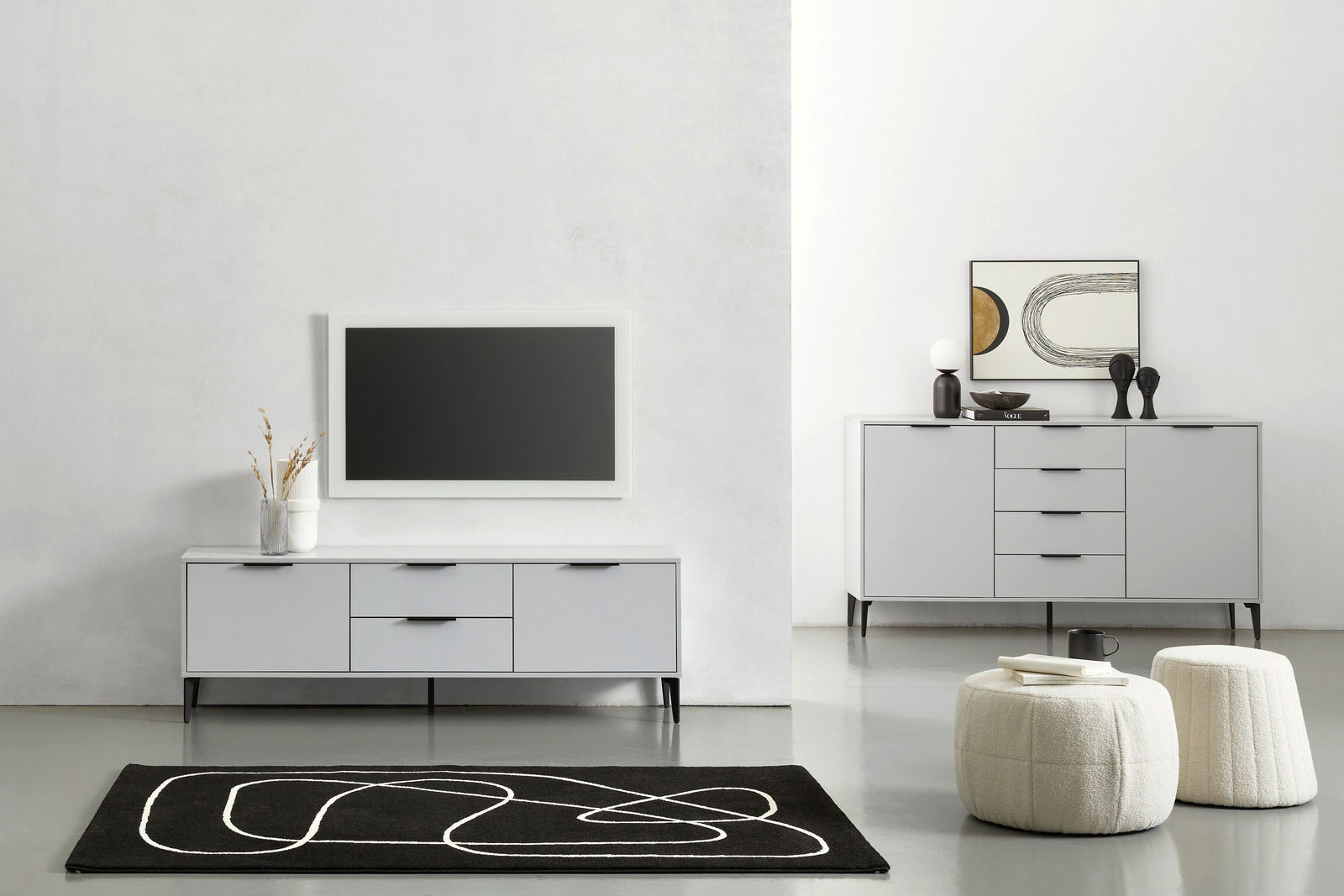 Moderne Wohnzimmermöbel in einem minimalistischen Raum, bestehend aus einem grauen TV-Lowboard und einem Sideboard, frontal betrachtet. Dekorative Elemente wie Vasen und Kunstwerke ergänzen das Design.
