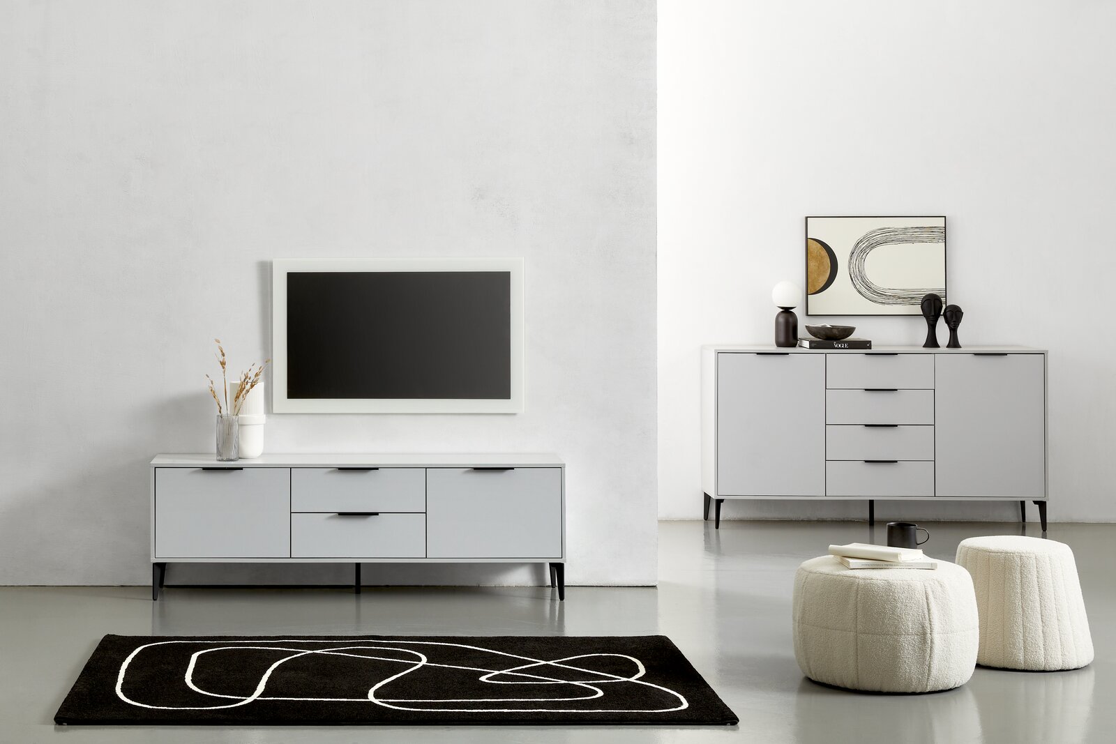 Moderne Wohnzimmermöbel in einem minimalistischen Raum, bestehend aus einem grauen TV-Lowboard und einem Sideboard, frontal betrachtet. Dekorative Elemente wie Vasen und Kunstwerke ergänzen das Design.