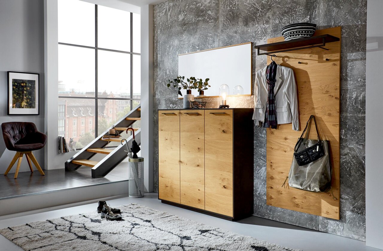 Moderne Garderobenkombination mit Holzoptik, bestehend aus Schuhkommode, Spiegel und Garderobenpaneel, seitliche Perspektive.