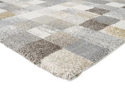 Frisé-Teppich mit kariertem Muster in Grau-, Beige- und Brauntönen, perspektivisch von der Seite fotografiert.