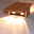 Moderne Wandleuchte aus Holz mit zwei sichtbaren Lichtquellen, seitliche Perspektive