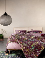 Bett mit Essenza Home Bettwäsche und Dekokissen AUGUSTINA in lila mit floralem Muster, seitliche Perspektive