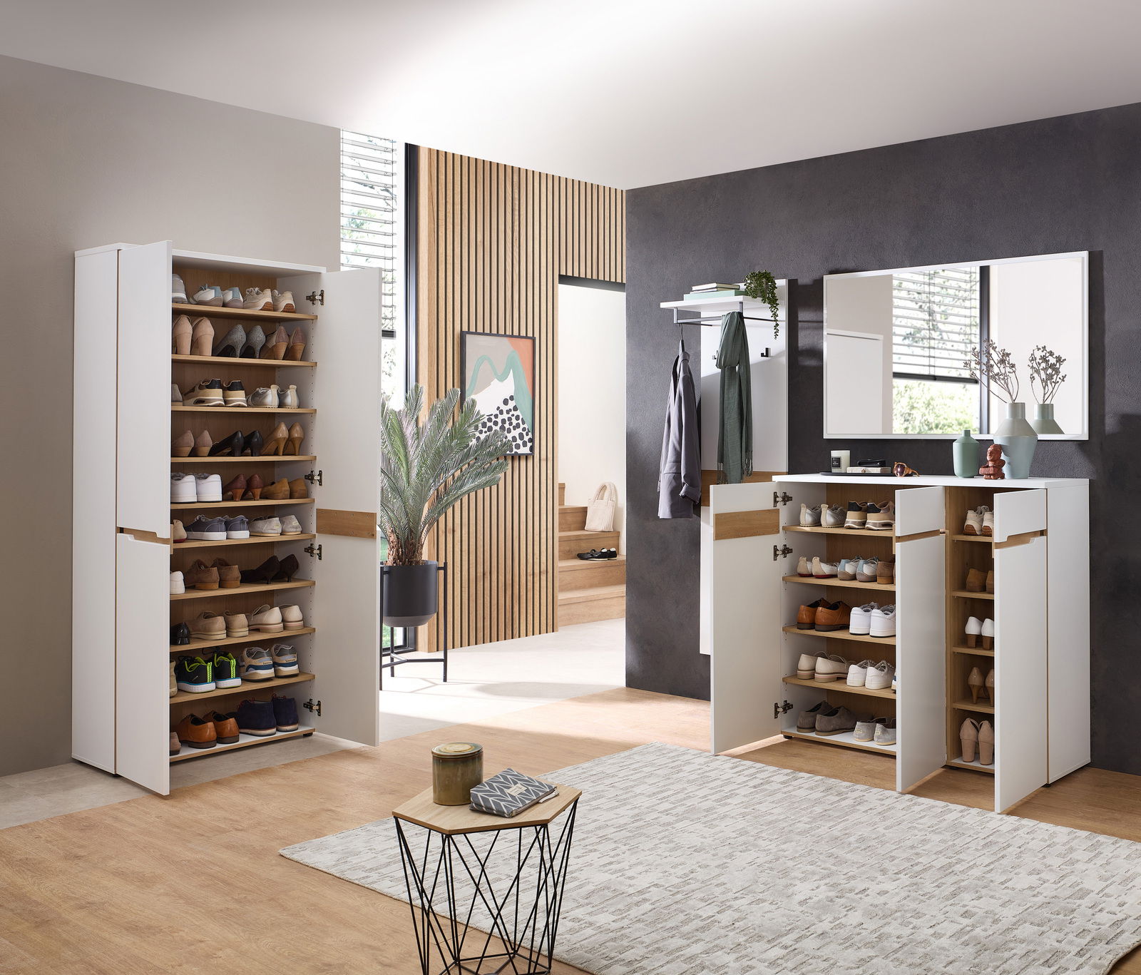 Moderner Eingangsbereich mit weißen Schuhschränken und Spiegel, seitliche Perspektive.