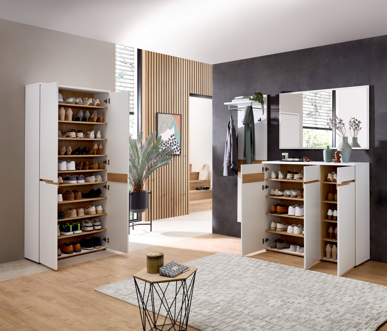 Moderner Eingangsbereich mit weißen Schuhschränken und Spiegel, seitliche Perspektive.