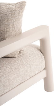 Close-up van een loungestoel met een beige stoffen bekleding en crèmekleurige armleuningen, gezien vanaf de zijkant.