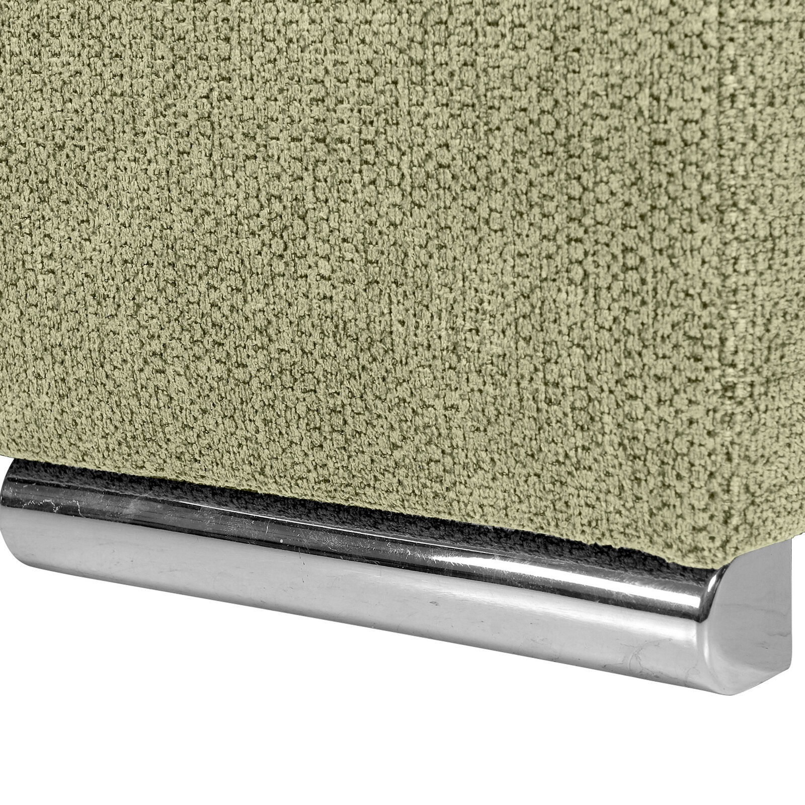 Nahaufnahme einer grünen, texturierten Stoffoberfläche mit einem glänzenden, metallischen Sockel.